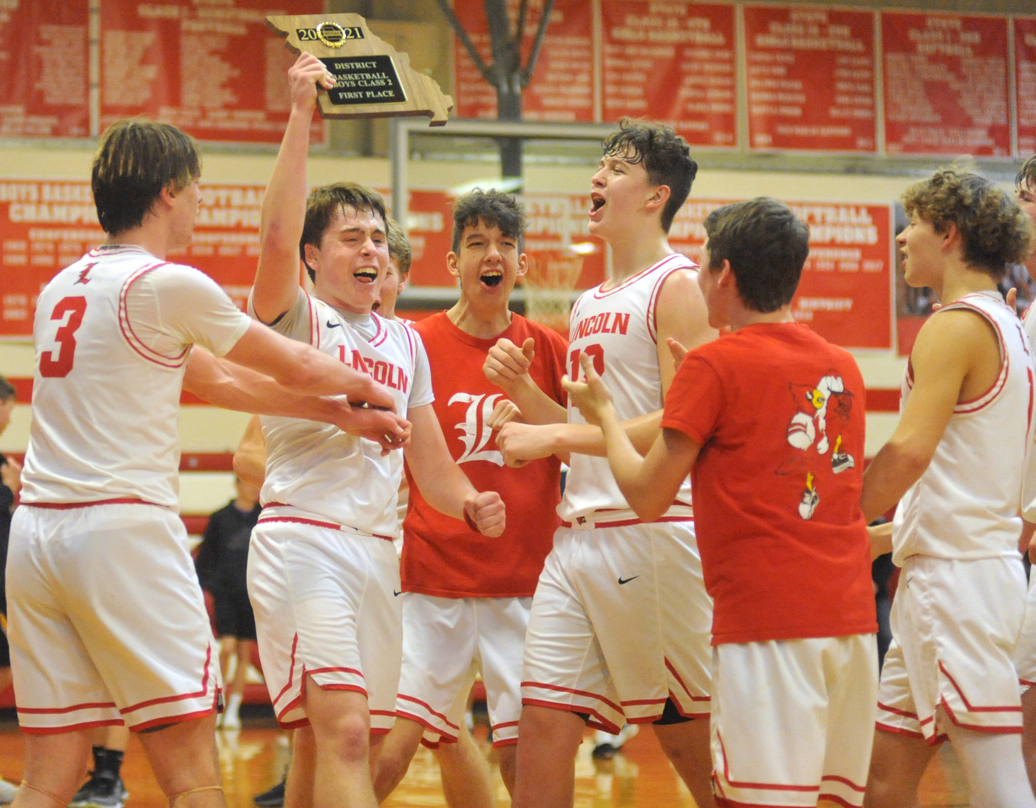 Cardinals senior Devon Parrott holds the district championship plaque Saturday, Feb. 27, 2021, as the team celebrates a 54-52 victory over Smithton at Lincoln R-2 School in Lincoln.